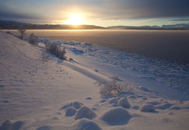 Low winter sun over the frozen shore of the Altafjord near Alta in Finnmark