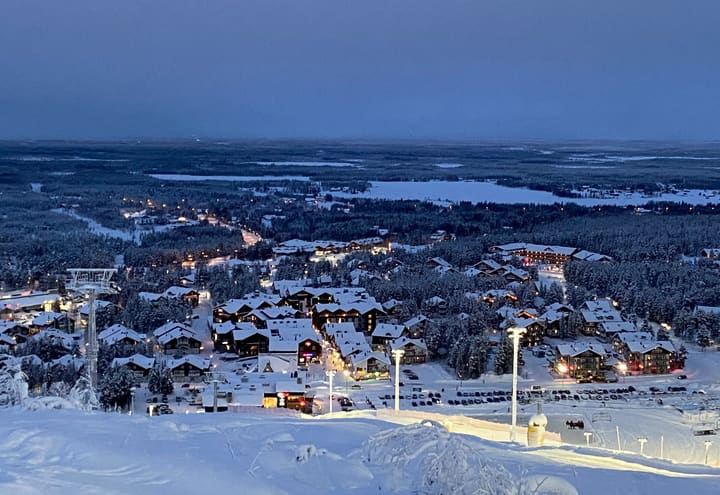 Levi resort village and Sirkka seen from the fell at dusk with snow-covered forest