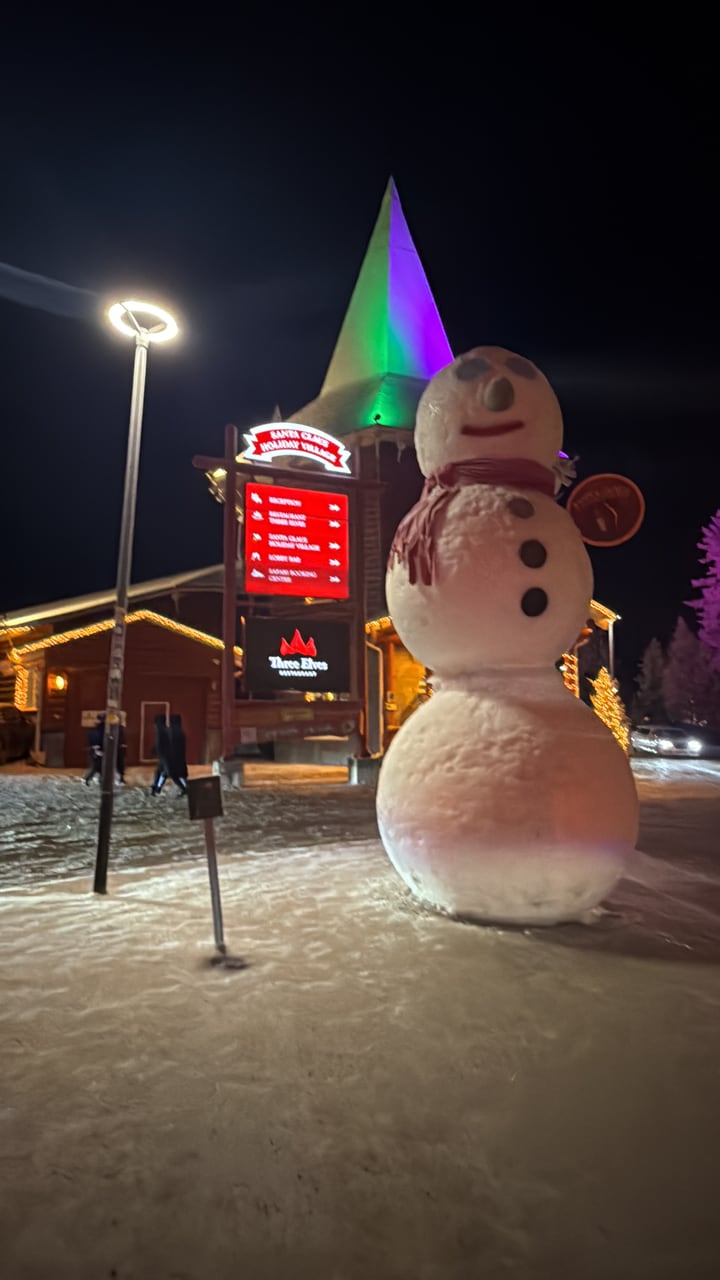 Snowman beside Santa Claus Holiday Village in winter