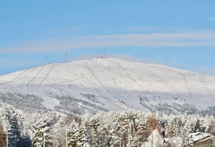 Snow-covered Ylläs fell with its ski slopes seen from the ice of Lake Ylläsjärvi